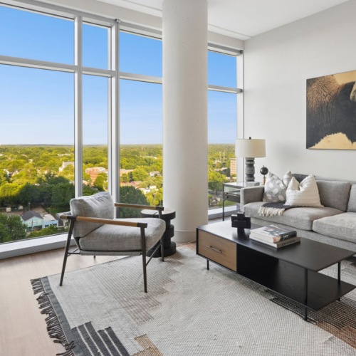 living room with couch chair coffee table and wall-sized window
